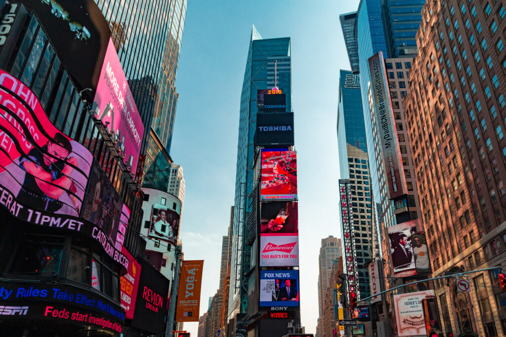 Times Square featuring large digital out-of-home billboards and illuminated brand advertisements surrounded by skyscrapers.