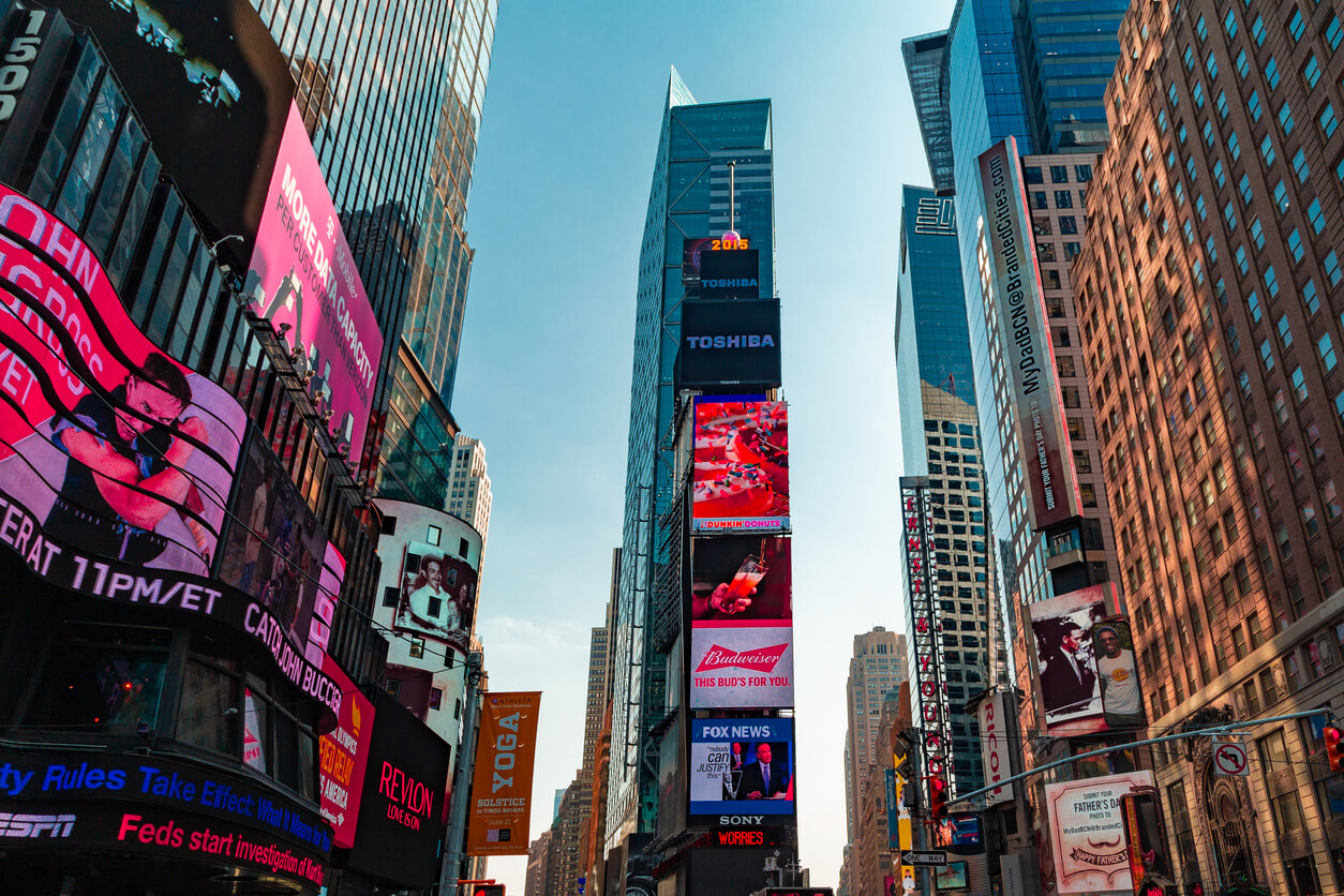 Times Square featuring large digital out-of-home billboards and illuminated brand advertisements surrounded by skyscrapers.