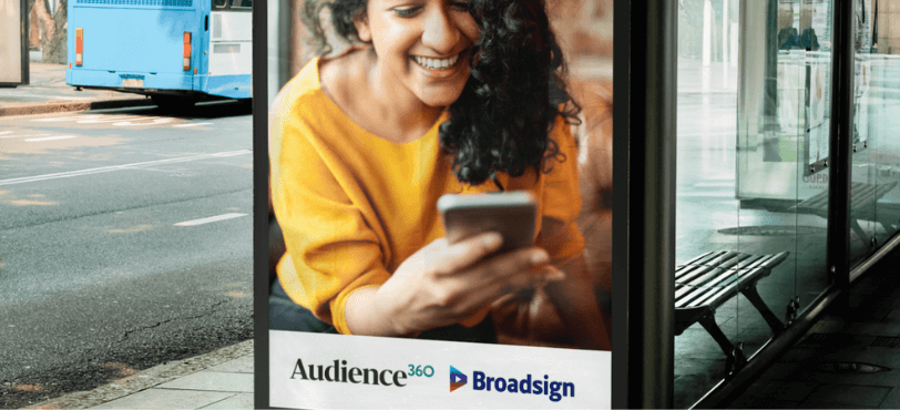 Audience360 and Broadsign graphic featuring a woman using her smartphone at a bus shelter.