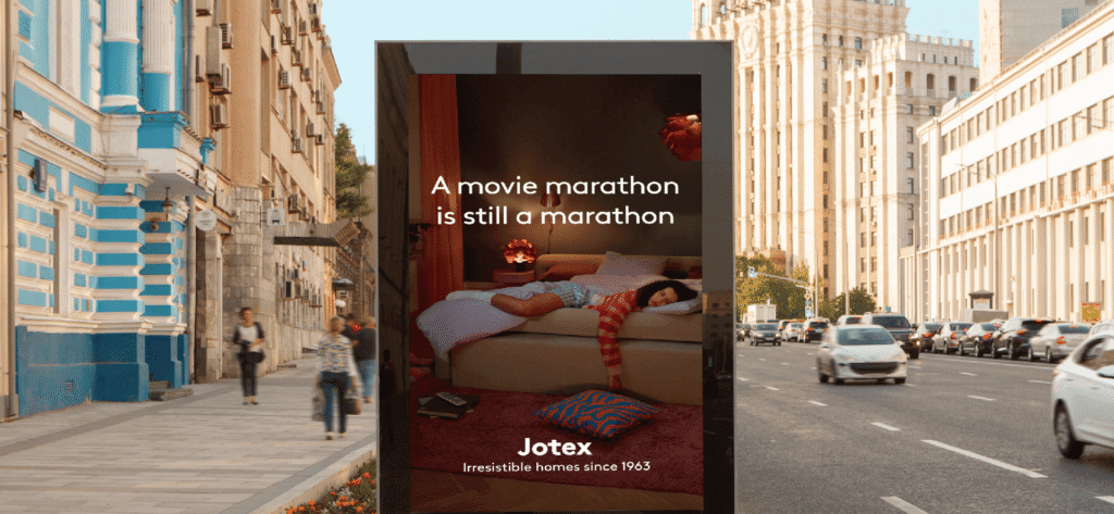 Jotex digital out-of-home ad featuring a person on a couch, displayed on a city street.