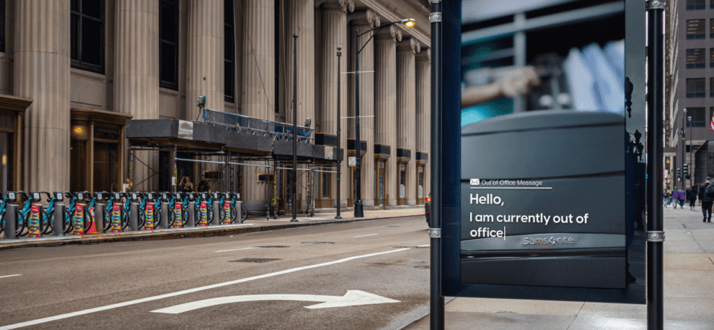 Samsonite digital out-of-home ad featuring an “out of office” message, displayed on a busy downtown street.