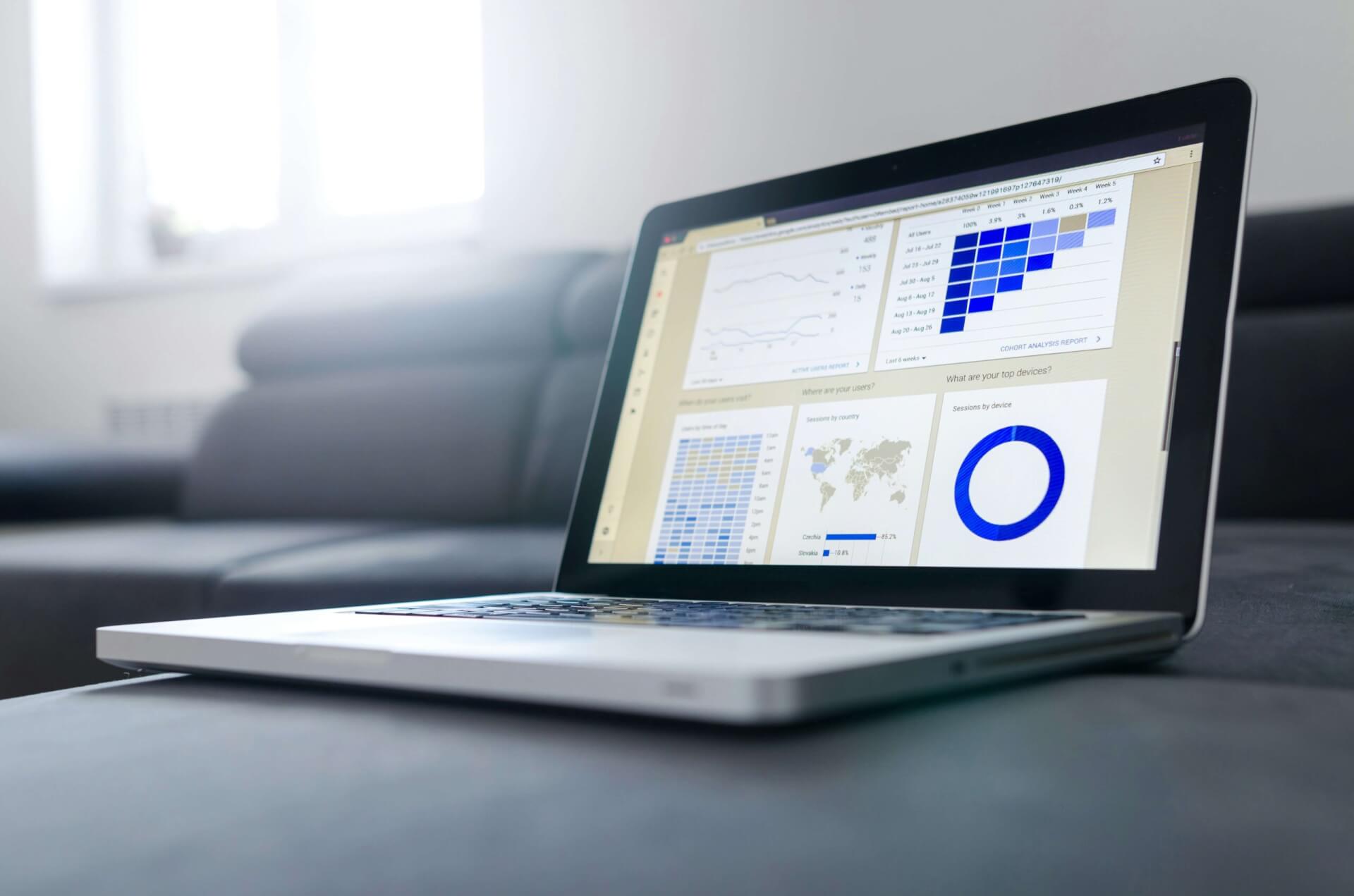 Laptop displaying an analytics dashboard with charts, graphs, and audience data.