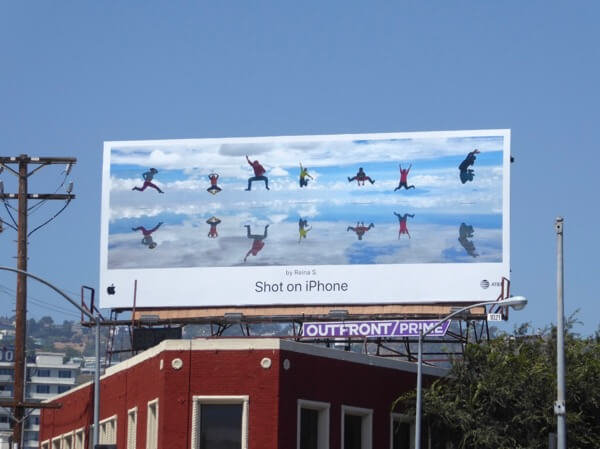 A billboard from Apple's "Shot on iPhone" campaign. It shows a group of people doing a timed shot where they all jumped in the air. It's a good example of how Apple used attractive imagery shot on iPhones to create billboards people notice.