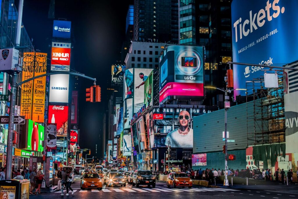 Times Square at night featuring large digital billboards and illuminated out-of-home advertisements.