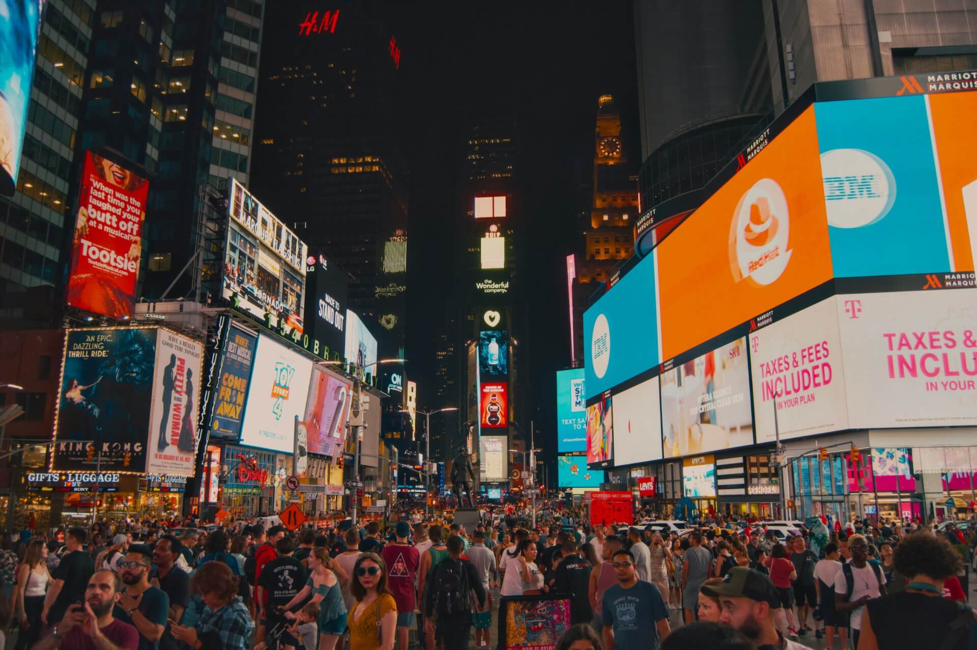 Times Square featuring large digital out-of-home billboards and illuminated brand advertisements surrounded by skyscrapers.