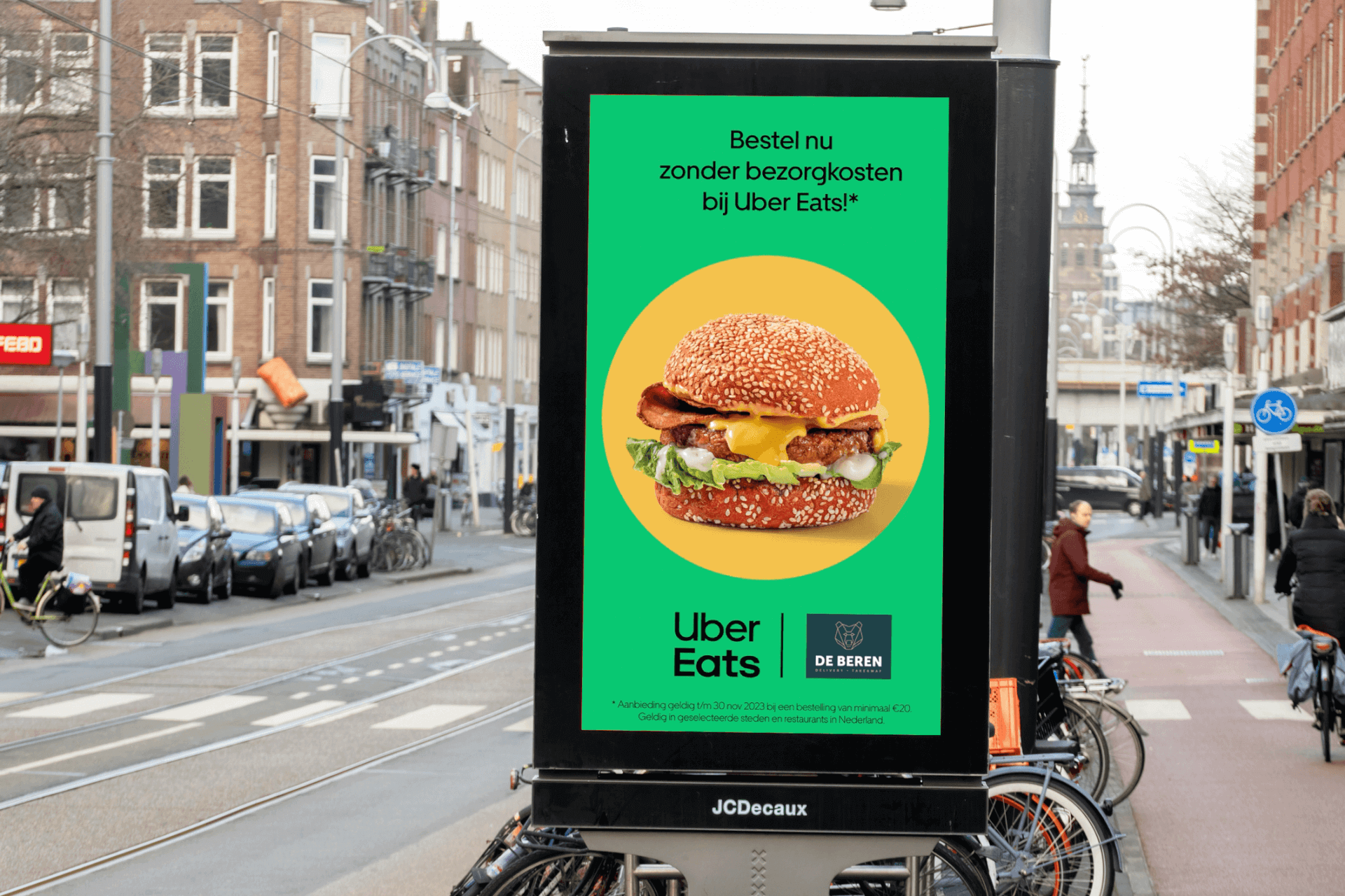Uber Eats and De Beren digital out-of-home ad featuring a burger and free delivery offer at a city transit shelter.
